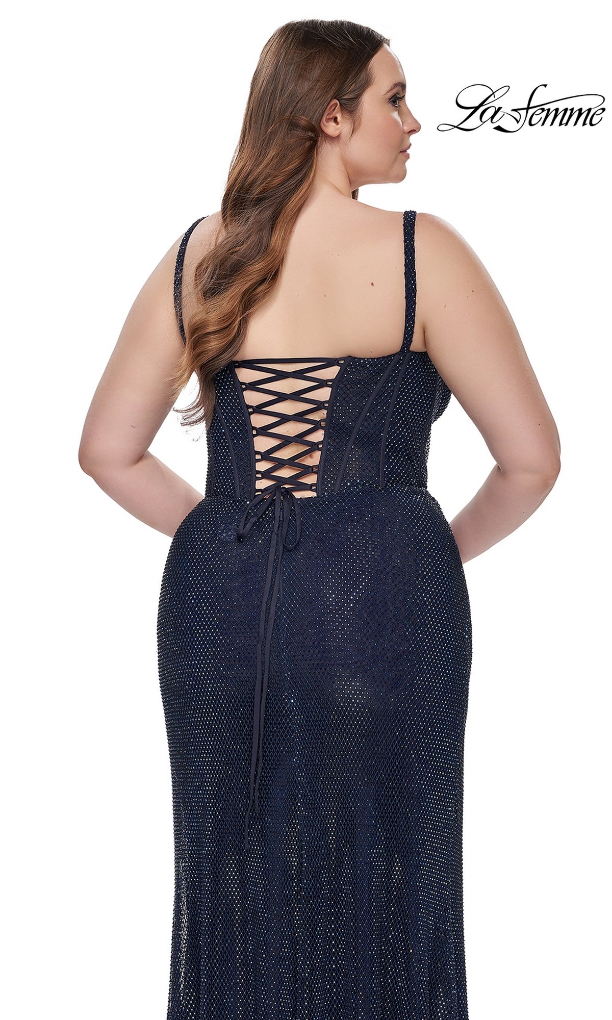 A woman is seen from behind wearing the La Femme Plus-Size Long Navy Blue Prom Dress 32243, which features a sleeveless design, lace-up corset back, and subtle sparkling accents.